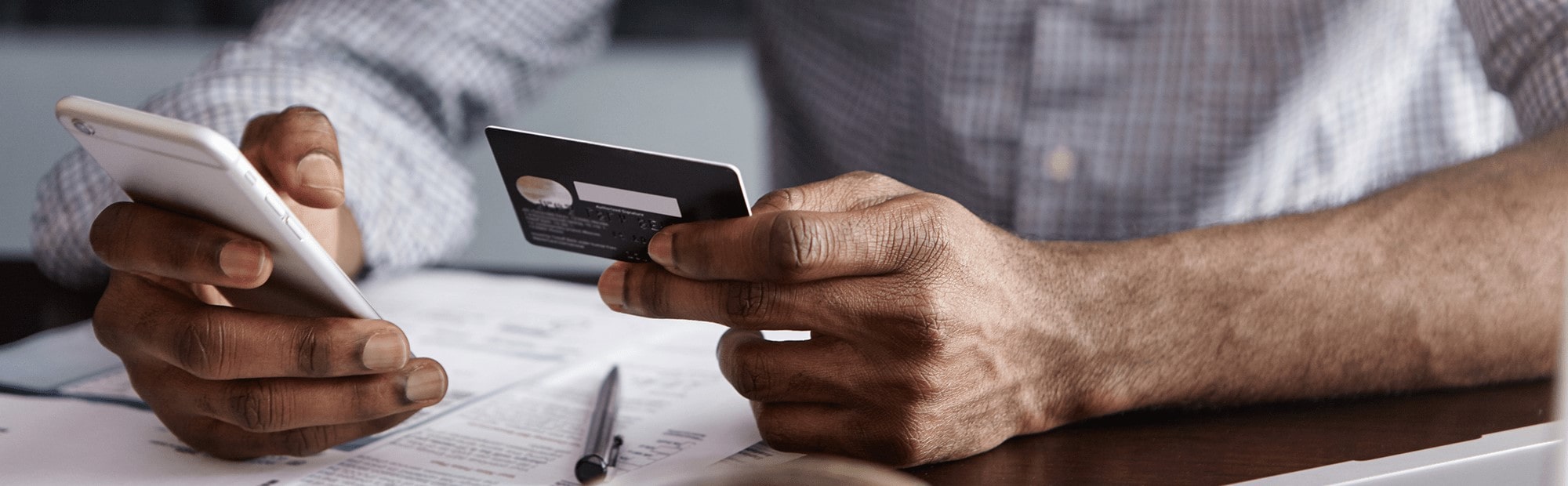 Man's hand holding a credit card