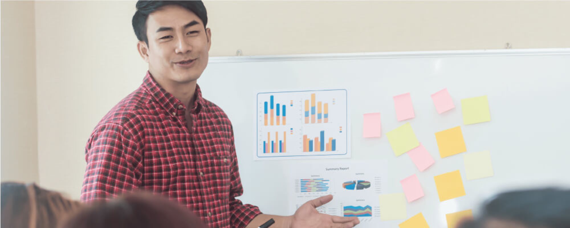 Man leading a brainstorming session with sticky notes on a white board